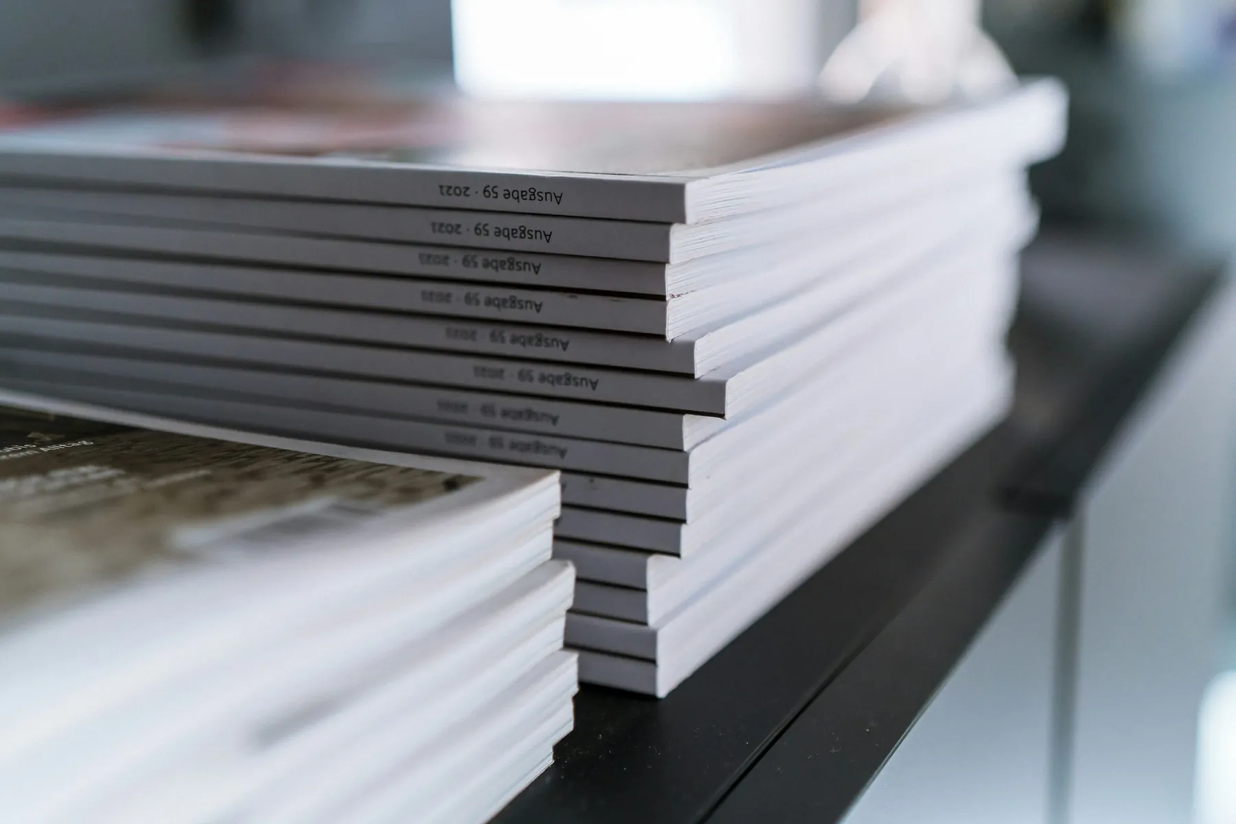 A stack of printed reports on a dark surface, seen along their edges.
