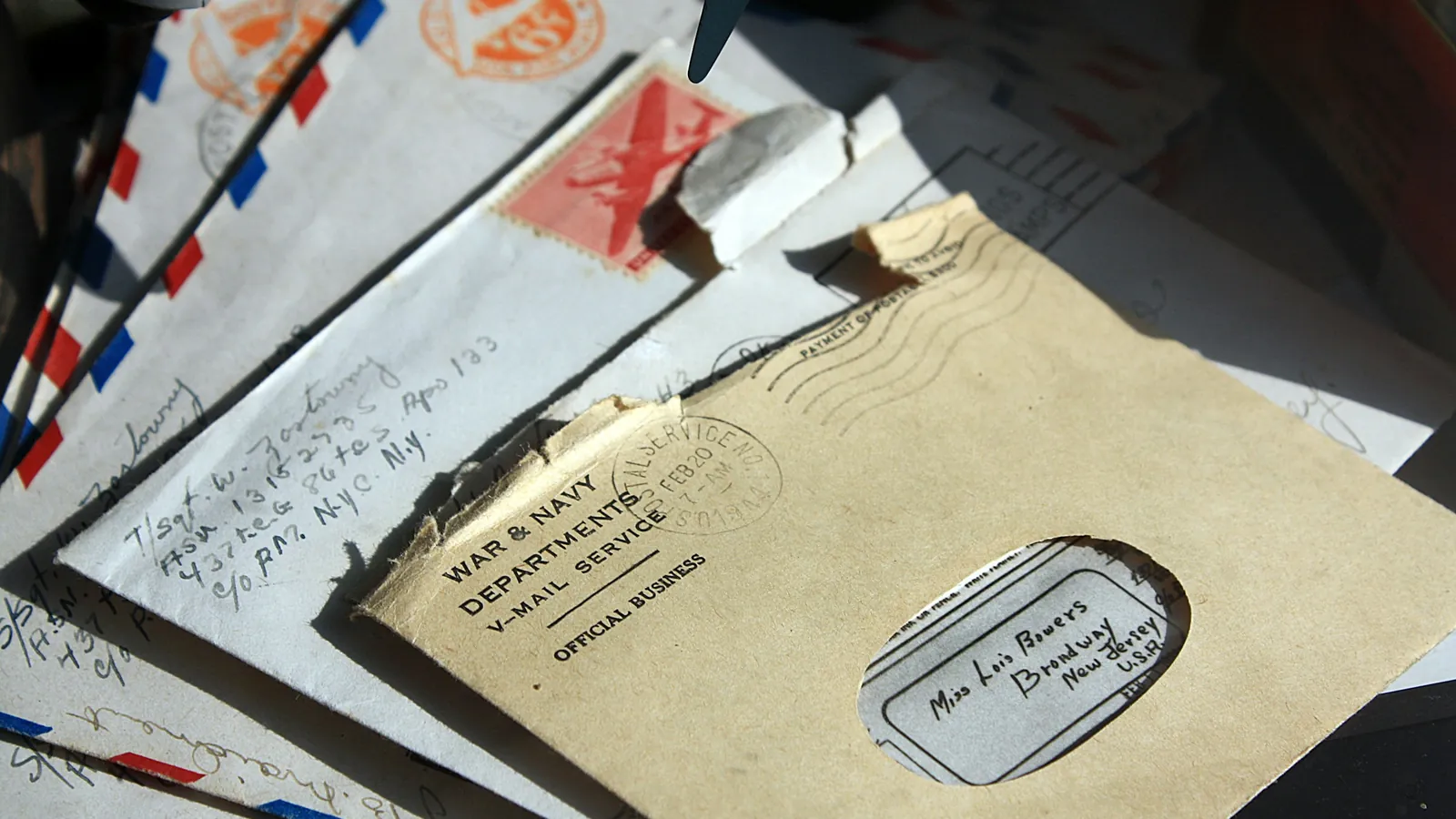 A pile of old airmail envelopes, stamped and addressed by hand.